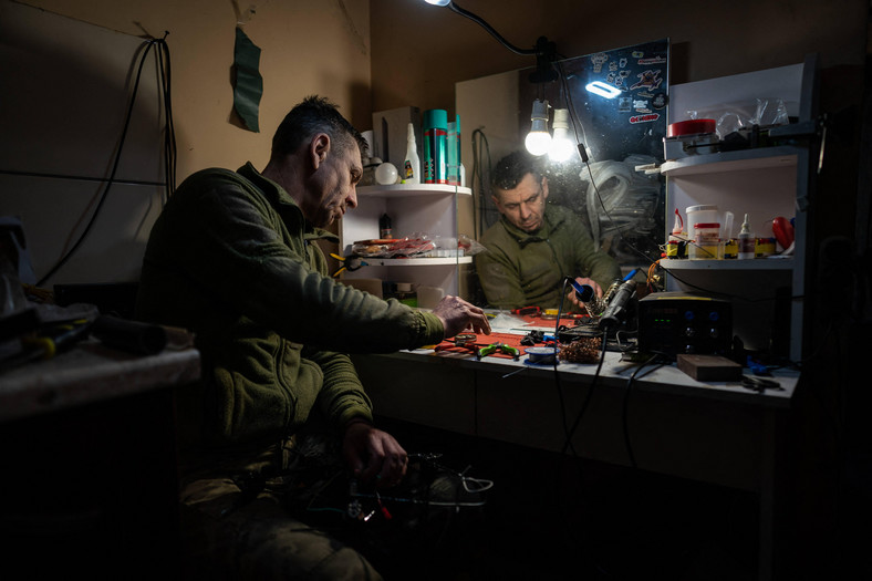 Ukraiński żołnierz modyfikuje drony w pobliżu linii frontu w Łymanie, początek marca 2024 r.