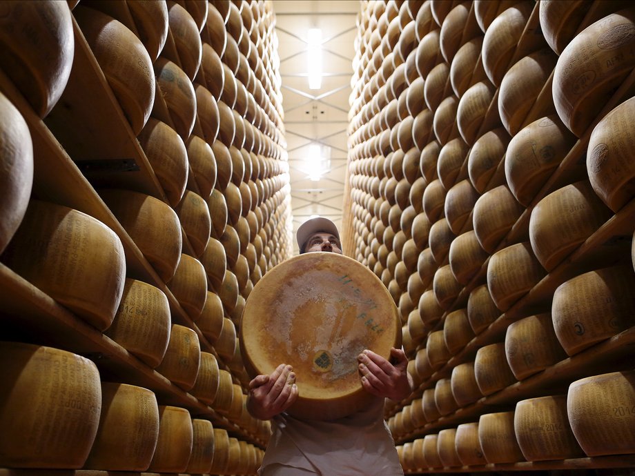 Worker carries fresh Parmesan wheel off storehouse shelf a 4 Madonne Caseificio dell'Emilia dairy cooperative in Modena, Italy, February 16, 2016.