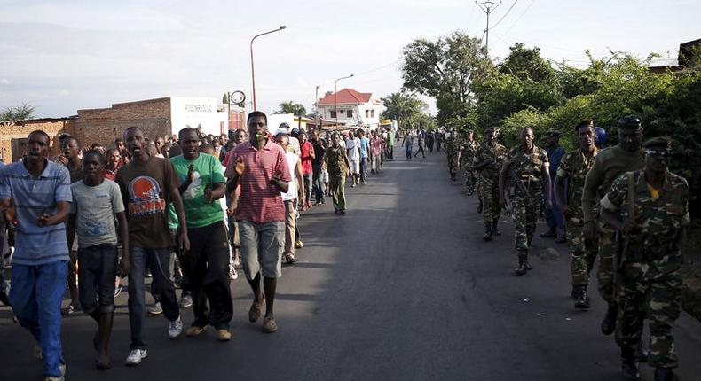 Protesters (L), escorted by soldiers (R), march during a demonstration against President Pierre Nkurunziza along a street in Bujumbura, Burundi, May 11, 2015.    REUTERS/Goran Tomasevic