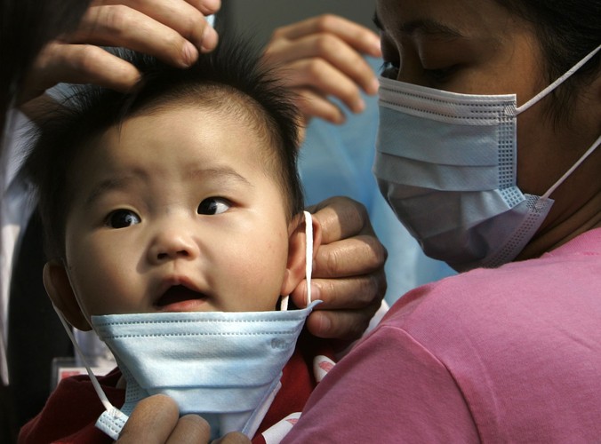 Maluch osłaniany maską tuż przed przyjęciem do szpitala w Hong Konkgu w 2008 roku. Z powodu epidemii grypy zamknięto wówczas szkoły i przedszkola