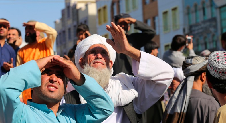 People look up at a dead body hanged by the Taliban from a crane in the main square of Herat city in western Afghanistan, on Saturday, September 29, 2021.
