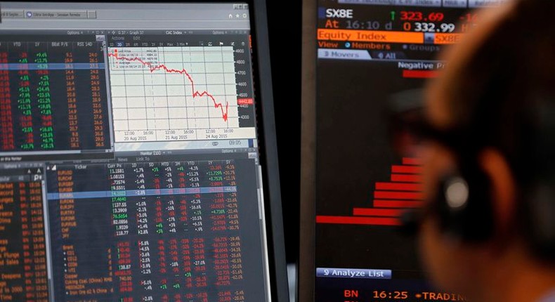 A sales manager sits near a screen with a graphic that shows a decline in value of French CAC 40 stocks at Allianz Global Investors in Paris, France, August 24, 2015. REUTERS/Regis Duvignau