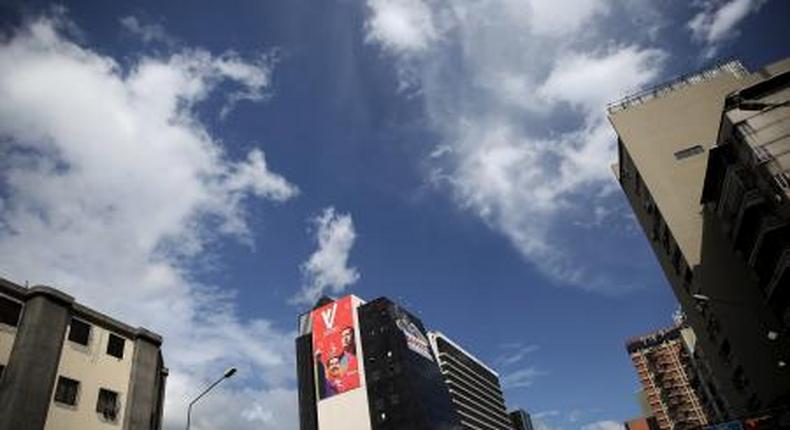 A banner (in red) with the images of Venezuelas President Nicolas Maduro and late Venezuelan President Hugo Chavez, is pictured on a wall of a building in Caracas, December 5, 2015.