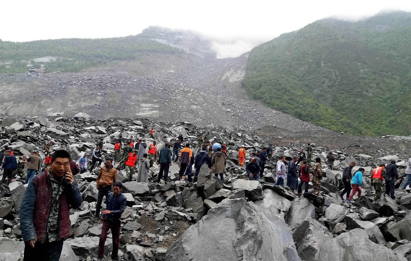 People search for survivors at the site of a landslide that occurred in Xinmo Village