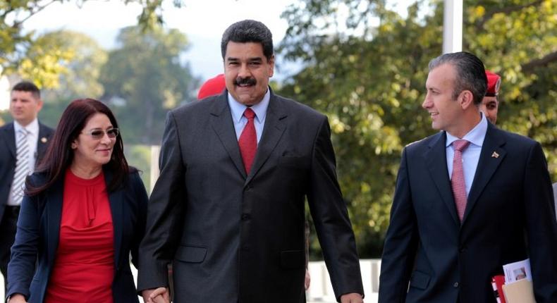 Handout picture released by the Venezuelan presidency showing President Nicolas Maduro (C) walking with his wife Cilia Flores (L) and new Vice-President Tareck El Aissami in Caracas on January 4, 2017