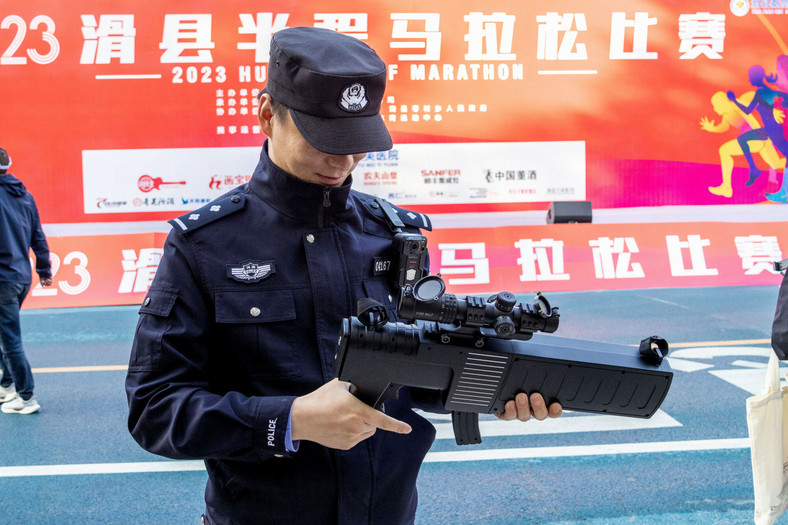 Funkcjonariusze policji trzymają bezzałogowe statki powietrzne podczas imprezy sportowej na dużą skalę w hrabstwie Hua, miasto Anyang, prowincja Henan w środkowych Chinach, 7 maja 2023 r. Urządzenie przeciwdziałające dronom to urządzenie służące do obrony, przechwytywania, zakłócania lub niszczenia dronów.