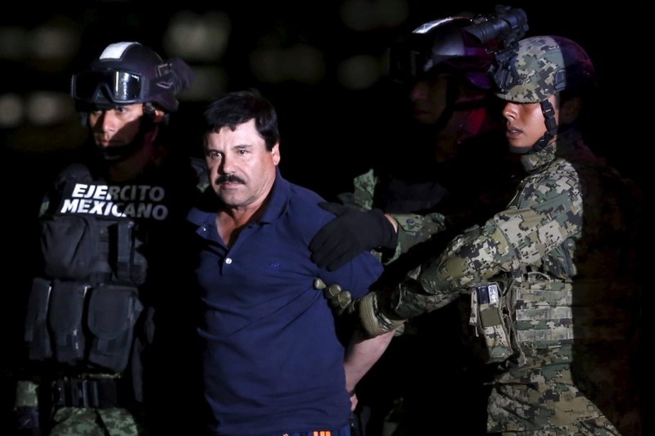 Joaquín "El Chapo" Guzmán is escorted by soldiers during a presentation at a hangar in Mexico City on January 8, 2016.