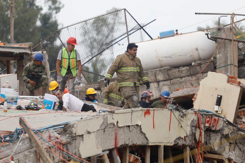 A rescue worker is helped during the search for students at Enrique Rebsamen school after an earthqu