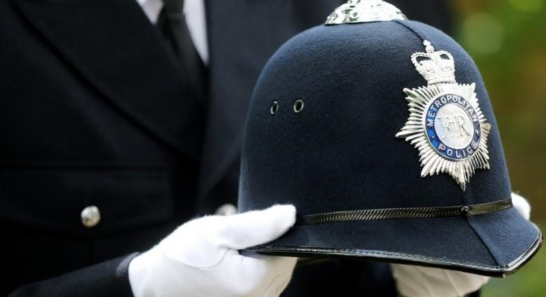 A police officer carries the helmet of Keith Palmer, the police officer killed in the March 22 Westminster terror attack, as he walks behind the coffin in the funeral procession in central London