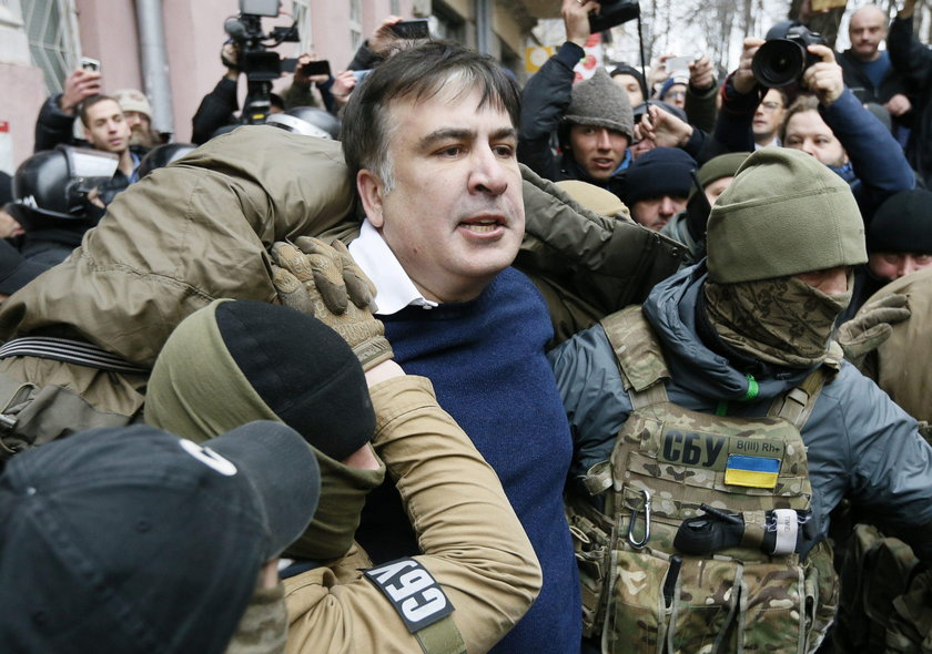 Supporters of Georgian former President Mikheil Saakashvili break a window a police car carrying Saa