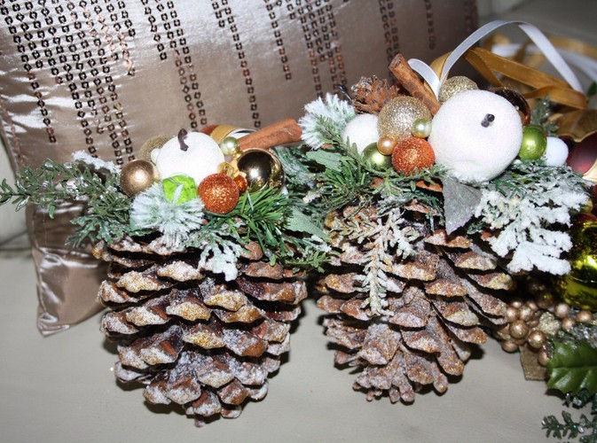 Ozdobne szyszki, udekorowane listkami, minibombkami, laskami cynamonu i białymi jabłuszkami. Autorka: Marta Jarosińska-Mańka