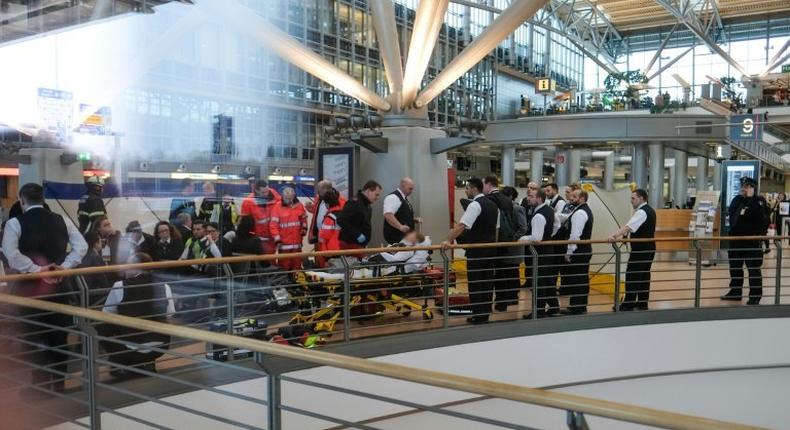 Firefighters take care of an individual on a stretcher inside Hamburg airport on February 12, 2017 in Hamburg, northern Germany, as emergency services evacuated the building after people reported respiratory ailments