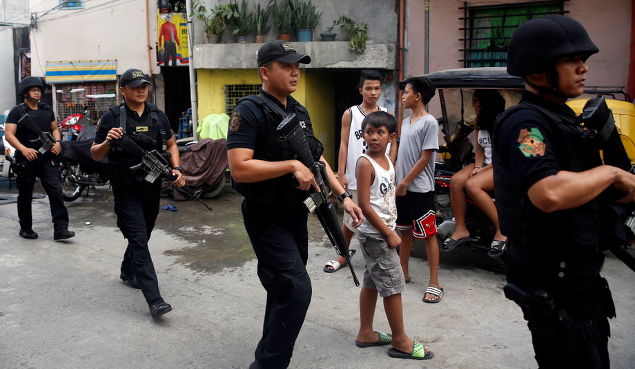 Members of Philippine National Police's SWAT team hold their weapons as they walk past residents during an anti-drugs operation in Mandaluyong, Metro Manila in the Philippines, November 10, 2016.
