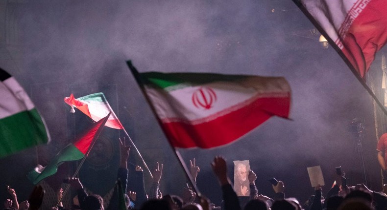 Iranians are waving Iranian flags and a Palestinian flag while one of them is holding a portrait of Qassem Soleimani, the former commander of the Islamic Revolutionary Guard Corps' (IRGC) Quds Force, in celebration of Iran's IRGC UAV and missile attack against Israel, in downtown Tehran, Iran, on April 14, 2024.Morteza Nikoubazl/NurPhoto via Getty Images