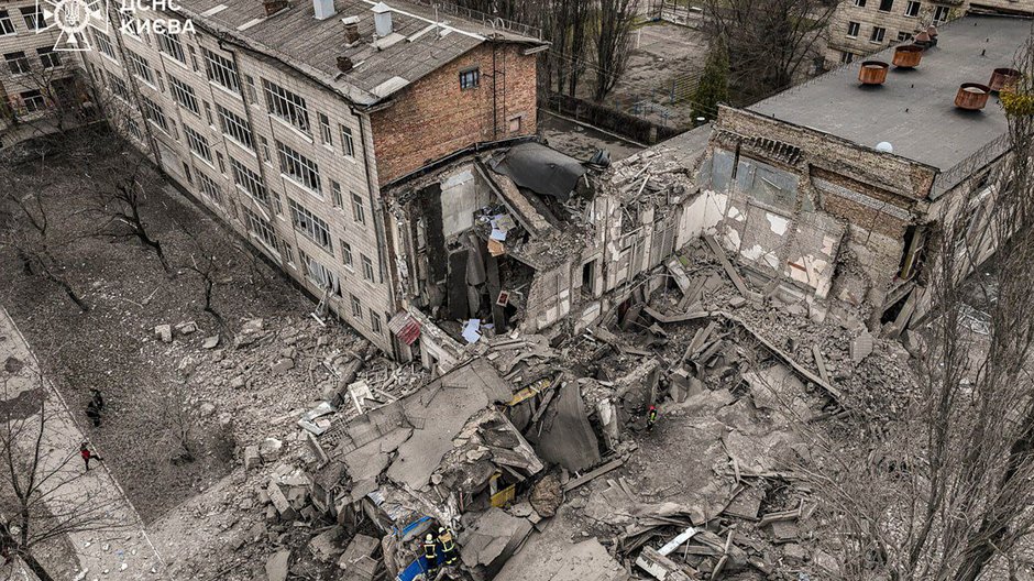 Zdjęcie pokazuje ukraińskich ratowników pracujących na miejscu uszkodzonego budynku po uderzeniu rakietowym w Kijowie. 25 marca 2024 r.