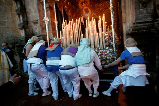 Costaleros leave a church as they take part in a procession during the Holy Week in Ronda