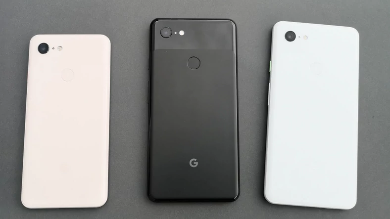 Porównanie rozmiarów i kolorów: po lewej Pixel 3 (5,5-calowy wyświetlacz) w odmianie "Not Pink", tuż obok Pixel 3 XL (6,3-calowy wyświetlacz) w wersji "Just Black". Po prawej kolor "Clearly White" 