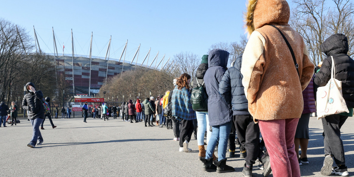 Uchodźcy stoją w kolejce do punktu nadawania PESEL w Stadionie PGE Narodowym.