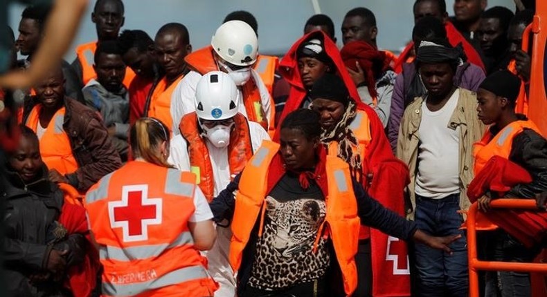 A migrant, who is part of a group intercepted aboard a dinghy off the coast in the Mediterranean sea, is helped by a member of Spanish Red Cross after arriving on a rescue boat at a port in Malaga, southern Spain, June 9, 2016. 