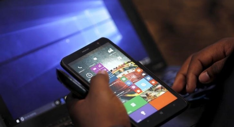 A Microsoft delegate checks applications on a smartphone during the launch of the Windows 10 operating system in Kenya's capital Nairobi, July 29, 2015. REUTERS/Thomas Mukoya