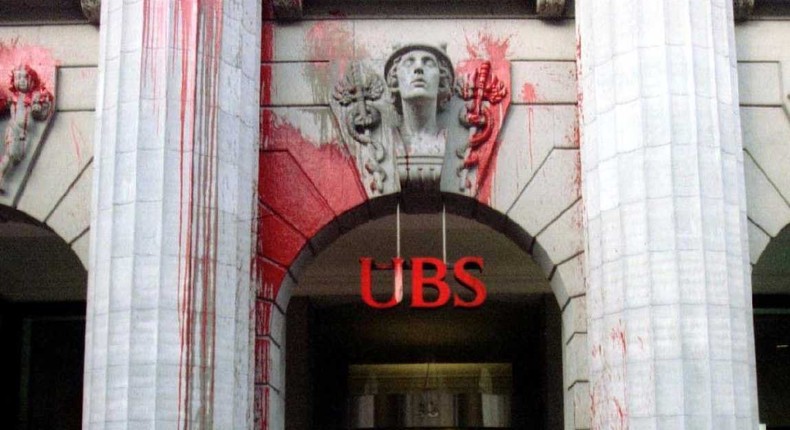 Workers clean off red paint from the headquarters of the Union Bank of Switzerland (UBS) in Zurich after a group of unidentified protesters hurled glasses filled with paint against the building in the early morning hours of April 14.