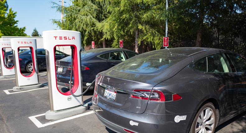 Tesla vehicles plugged in and charging at a Supercharger rapid battery charging station.Smith Collection/Gado/Getty Images