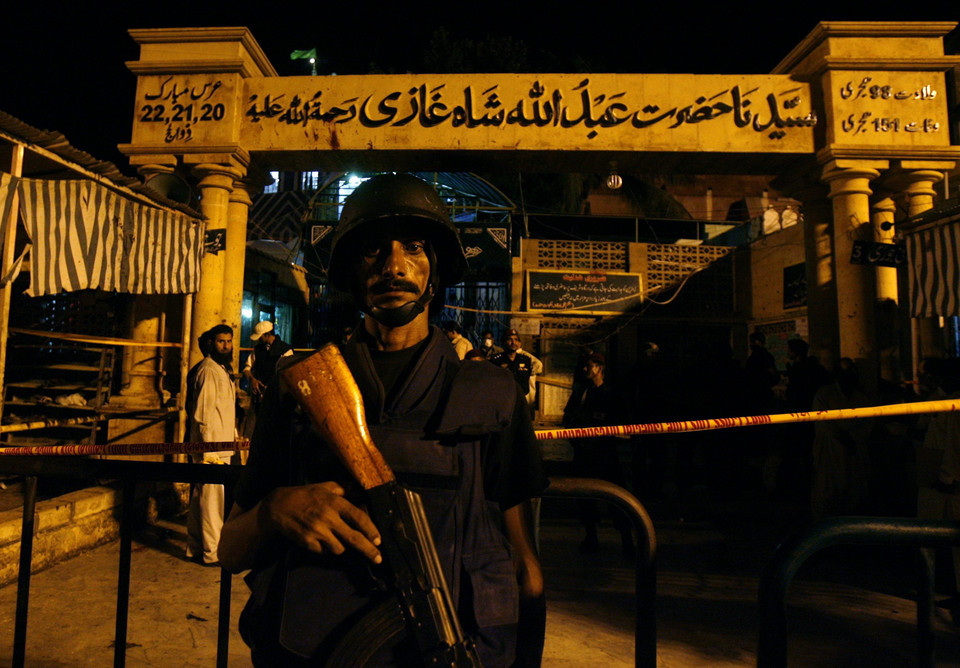 A policeman stands guard outside a Sufi shrine after it was hit by multiple suicide blasts in Karachi