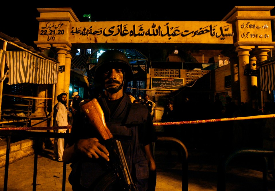 A policeman stands guard outside a Sufi shrine after it was hit by multiple suicide blasts in Karachi