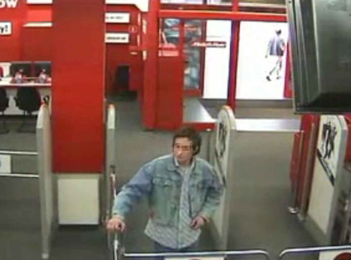 Niepełnosprawny umysłowo chłopak tańczy przed bramką wejściową do elektronicznego marketu