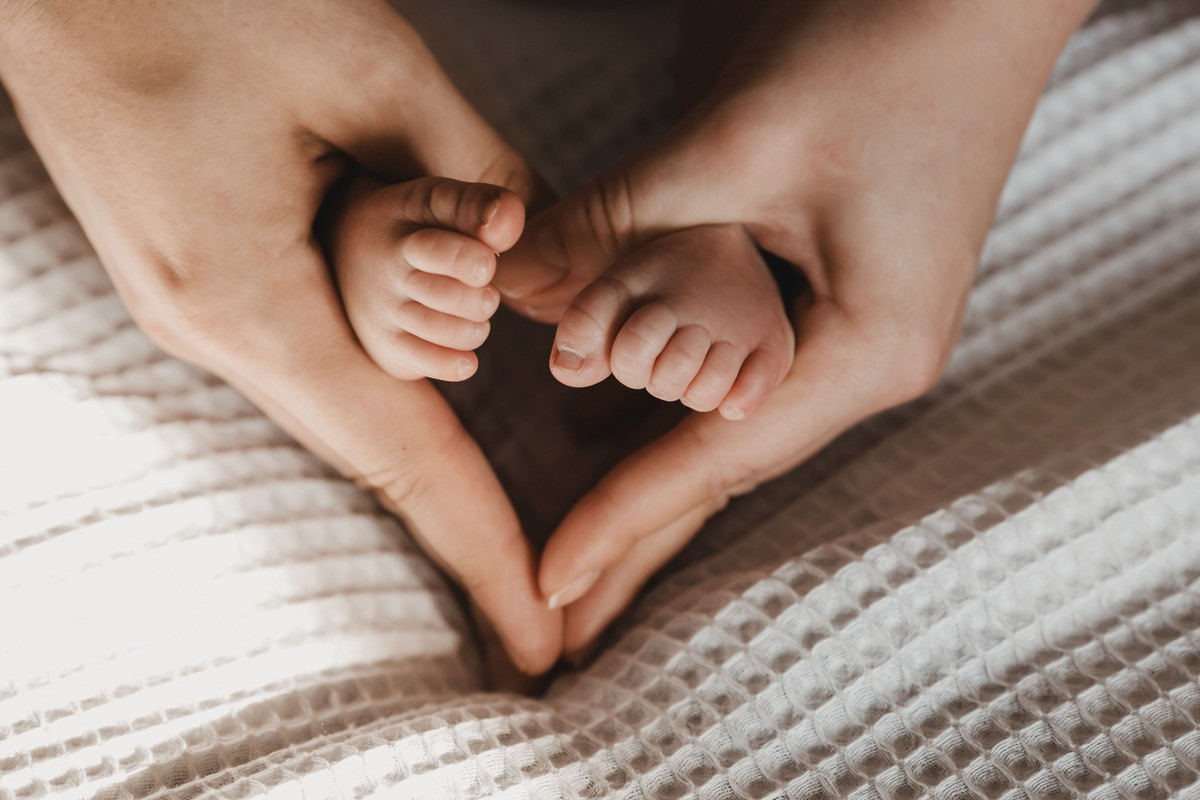 Woman,Makes,Heart,With,Her,Hands,And,Holds,Tiny,Baby's