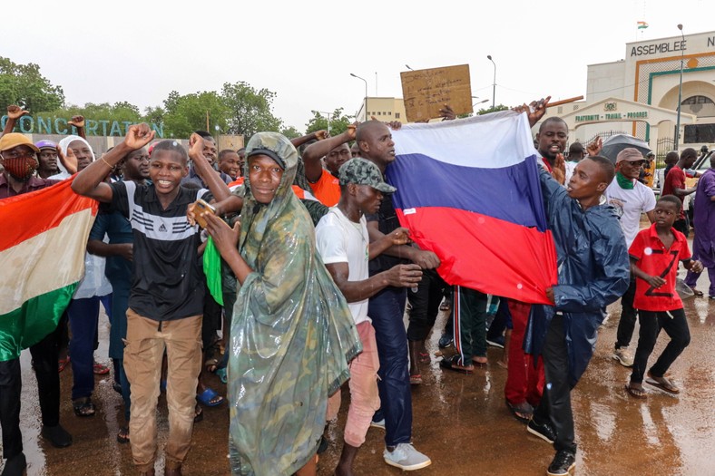 Zwolennicy puczystów trzymają flagi Nigru i Rosji podczas świętowania przed budynkiem Zgromadzenia Narodowego w Niamey, Niger, 27 lipca 2023 r.