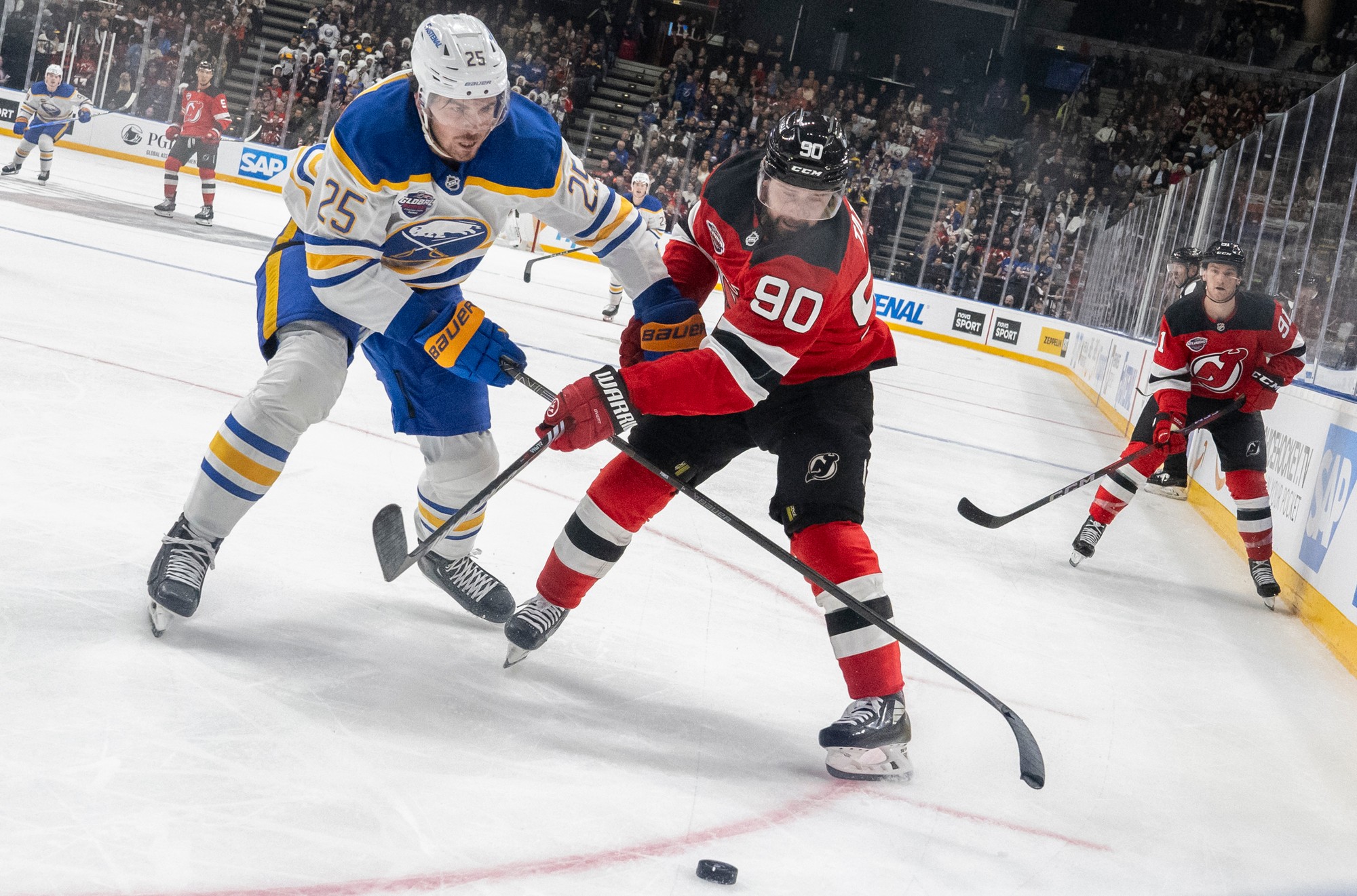 Slovenský hokejista Tomáš Tatar (v popredí vpravo)  v drese New Jersey Devils a Dylan Cozens z Buffala Sabres.