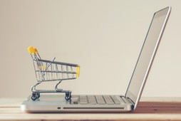 Small Shopping Cart On Laptop With Copyspace : Online Shopping Concept. E-commerce.