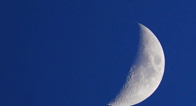 The International Space Station looking like a white dot as it passes the Moon, as seen from Liverpool.Peter Byrne/PA Images via Getty Images