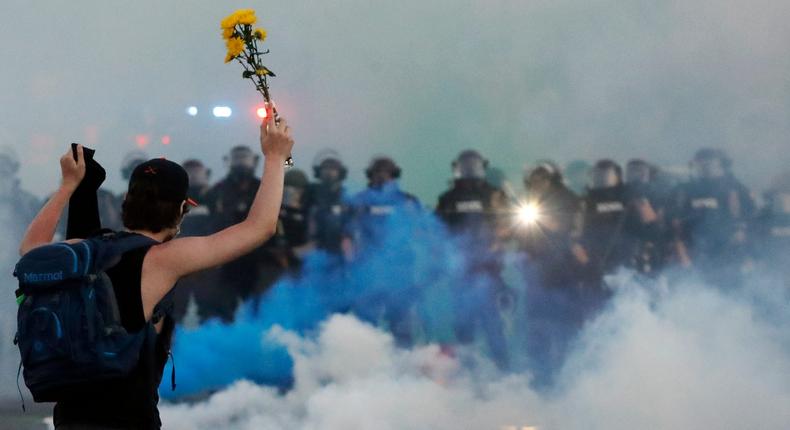 Police move towards a protester after curfew Saturday, May 30, 2020, in Minneapolis. Protests continued following the death of George Floyd, who died after being restrained by Minneapolis police officers on Memorial Day. (AP Photo/John Minchillo)