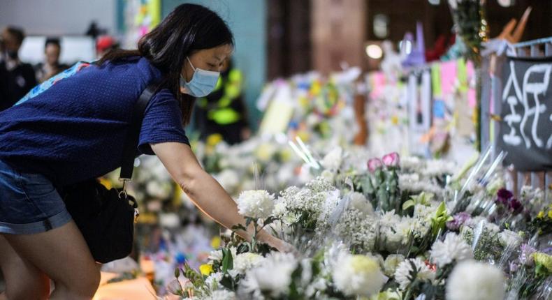 Mourners pay their respects at the site where a student fell to his death during a recent protest