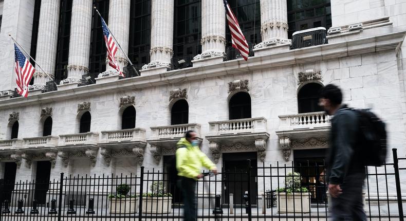 Men cruise past the New York Stock Exchange in Manhattan.
