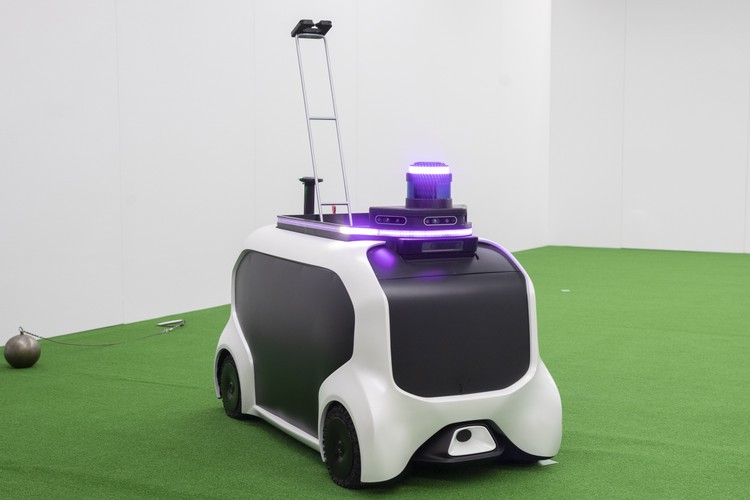 Podczas igrzysk w Tokio do zbierania oszczepów i młotów z 'pola rażenia' będzie używany autonomiczny robot pomocniczy nowej generacji. Jest to miniaturowe urządzenie oparte na opracowywanym przez Toyotę pojeździe „e-Palette”. 
<br>
Pojazd jest wielkości samochodzika dla dzieci, mimo to może rozwijać maksymalną prędkość 20 kilometrów na godzinę. Wyposażony jest w trzy kamery i jeden czujnik umożliwiający „widzenie” otoczenia.
<br>
Na górnej części pojazdu znajduje się zespół świateł LED, które informują, kiedy pojazd wykorzystuje sztuczną inteligencję. To właśnie dzięki AI robot śledzi zachowanie obsługi oraz tor lotu kuli, dysku, młota i oszczepu rzucanych przez sportowców.
