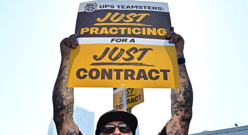 UPS workers hold placards at a rally in Los Angeles, California, ahead of an August 1st deadline for an agreement on a labor contract deal and to avert a strike that could lead to billions of dollars in economic losses.Frederic J. Brown/AFP via Getty Images