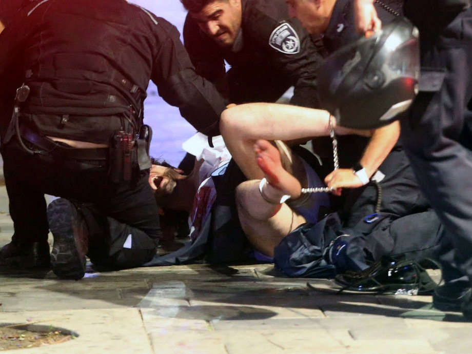 Israeli policemen arrest a suspected man following a shooting attack that took place in the center of Tel Aviv on June 8.
