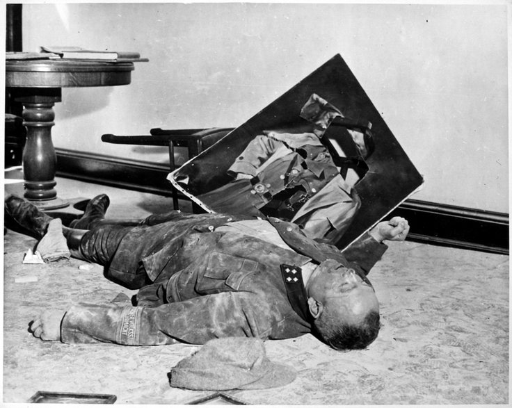 Ciało majora Volkssturmu Waltera Dönicke leżące obok podartego portretu Adolfa Hitlera. Dönicke popełnił samobójstwo w Ratuszu w Lipsku, na krótko przed przybyciem wojsk amerykańskich 19 kwietnia 1945 r.