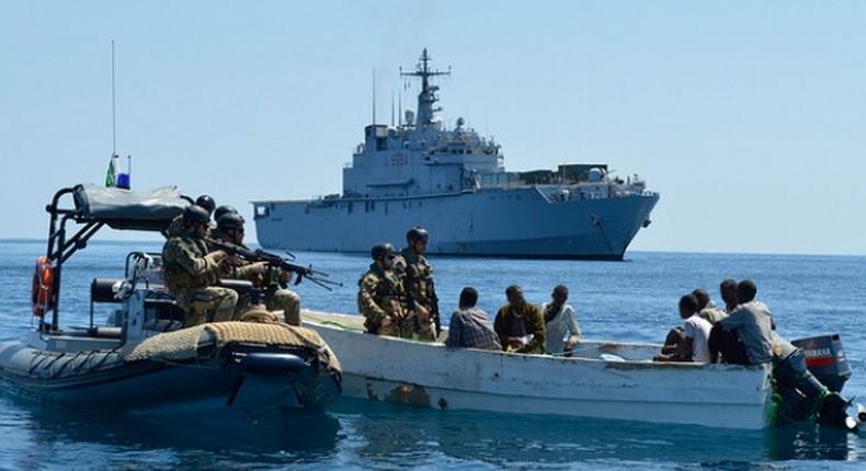 Navy personnel on routine patrol searching a boat on the sea (Illustration)