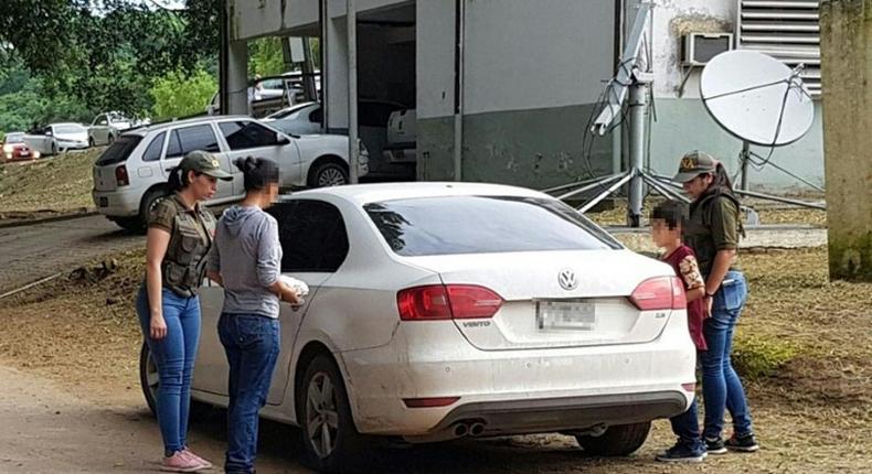 An Argentine woman (2-L) who was abducted 32 years ago and her nine-year-old son (2-R) being escorted by police officers into a car in Oran, Salta Province, Argentina