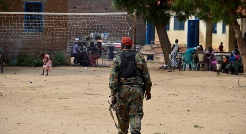 A soldier from the Sudan People's Liberation Movement (SPLM) walks within families displaced in recent fighting camping at the Anglican church compound in Juba, South Sudan, July 12, 2016. 