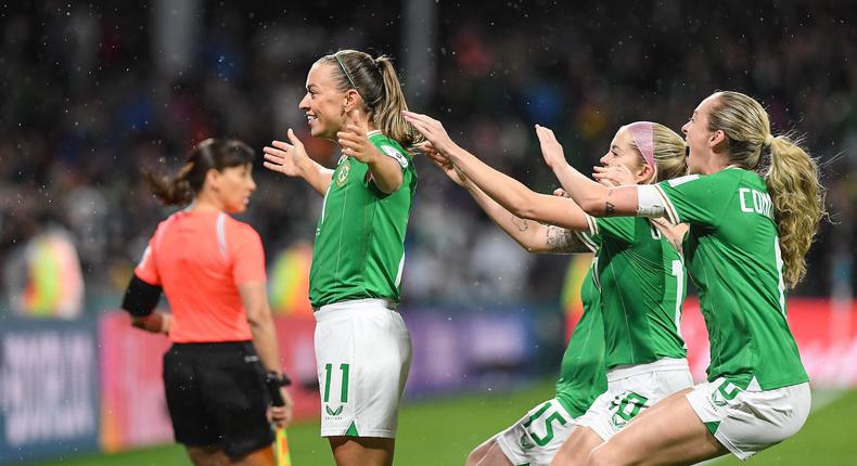 Katie McCabe gestures to the crowd as teammates rush to celebrate her historic Olimpico goal.Mick O'Shea/Sportsfile via Getty Images