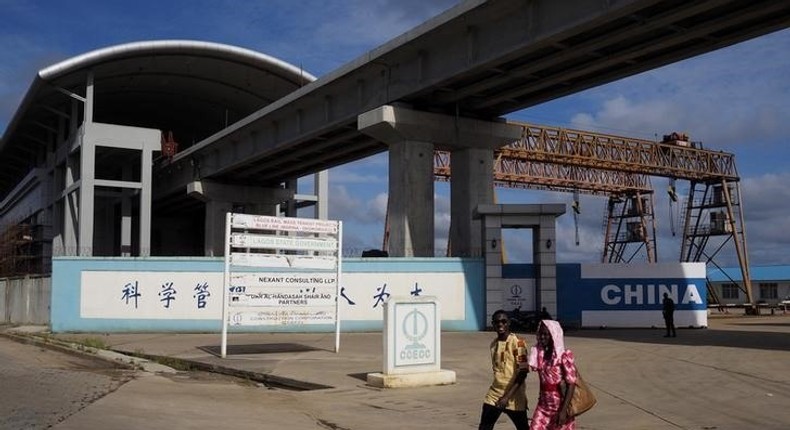 People walk by the National Arts Theatre stop of the light rail system under construction in Lagos, Nigeria, May 30, 2014. REUTERS/Joe Penney