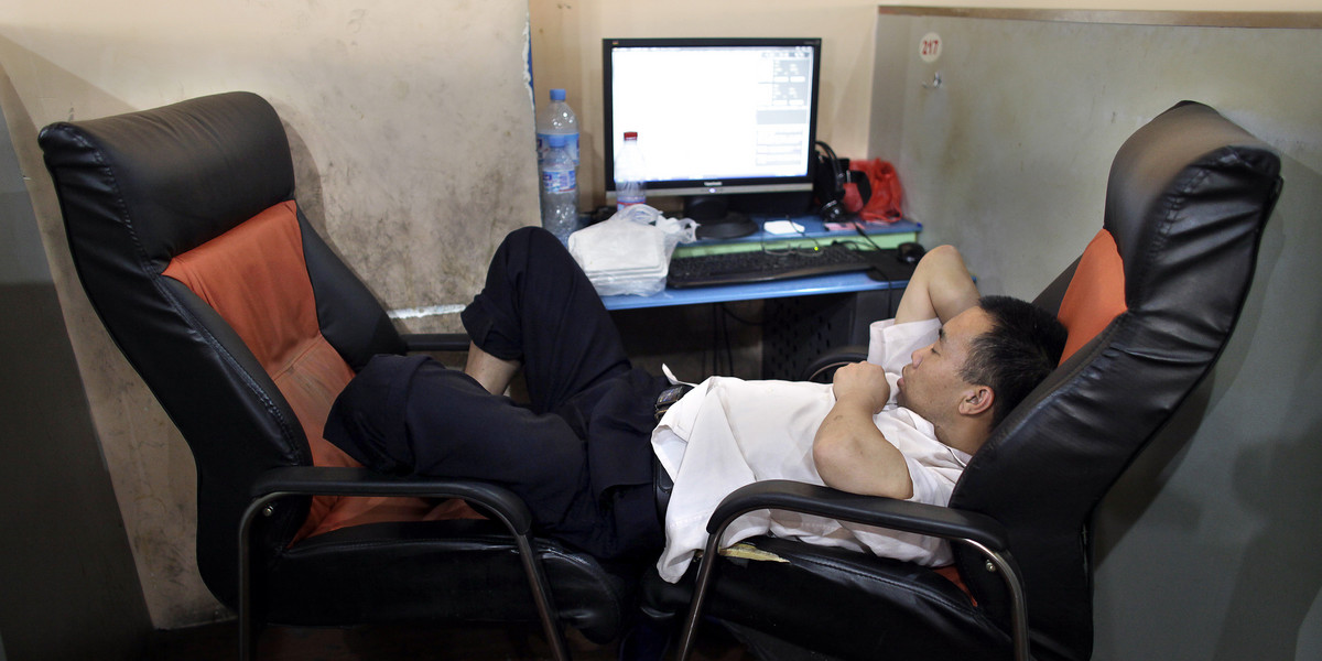 A man takes a nap next to a computer at an internet cafe in downtown Shanghai July 1, 2009.