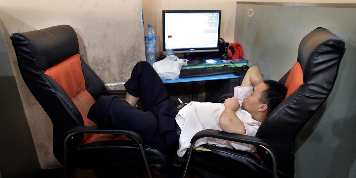 A man takes a nap next to a computer at an internet cafe in downtown Shanghai July 1, 2009.