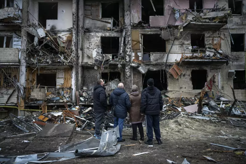 Mieszkańcy patrzą na bloki zniszczone w rosyjskim ataku rakietowym, Kijów, 25 lutego 2022 r. / East News