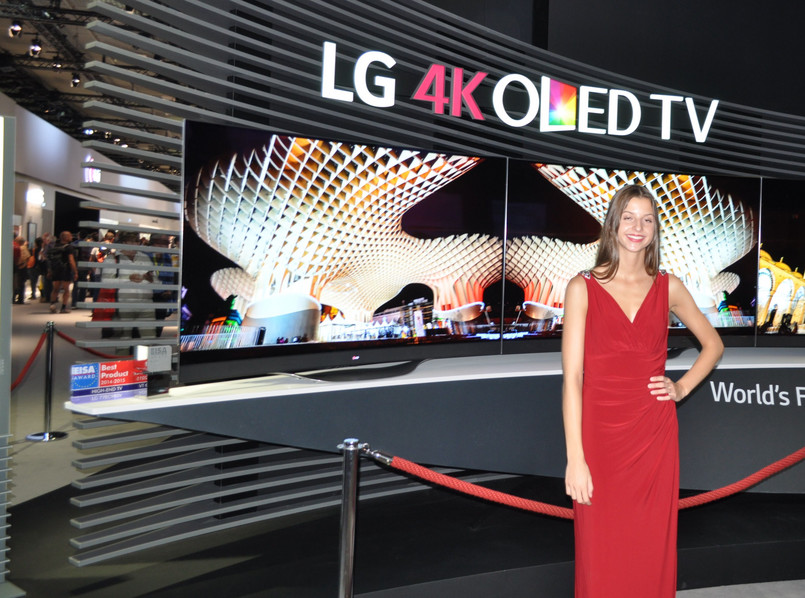 Piękna kobieta pokazuje piękny telewizor OLED 4K